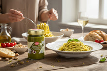 Laden Sie das Bild in den Galerie-Viewer, Feinkost Ranieri Pistazien Pesto aus Sizilien, 190g, in einer stilvollen Lifestyle-Darstellung auf einem Tisch.